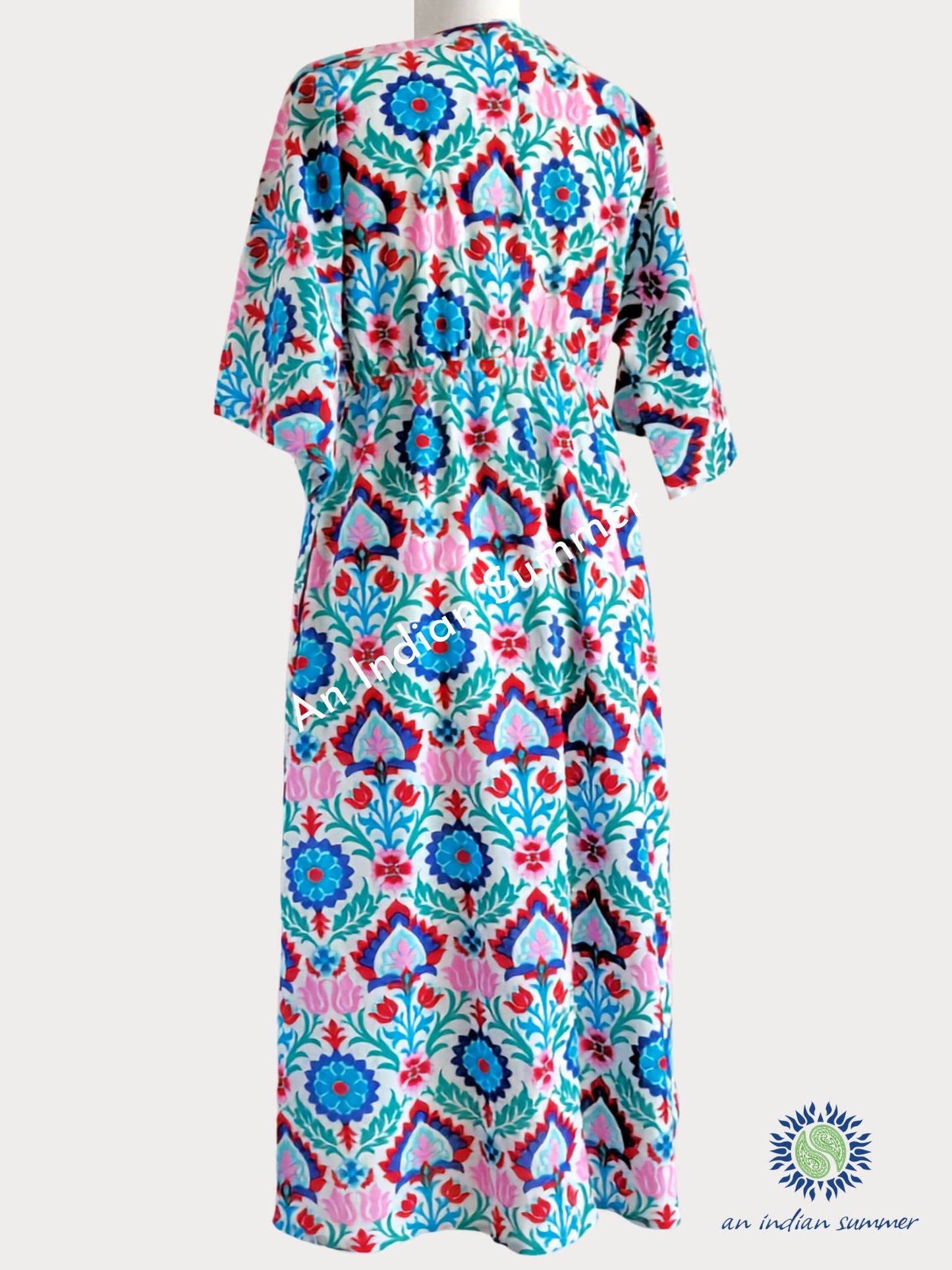 A multicolour Suzani Print printed cotton kaftan dress with a pink, turquoise, blue, and green geometric and floral pattern. An Indian Summer Samara Cotton Dress Turquoise & Pink Comfortable Easy-fit Summer Dress Ideal for Lounging or on the beach | Elasticated back | One Size | Cotton Voile | Handcrafted
