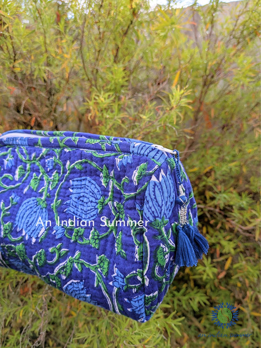 A blue washbag with a floral hand block print and beaded tassels.